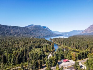 Un área boscosa con un lago y montañas al fondo.