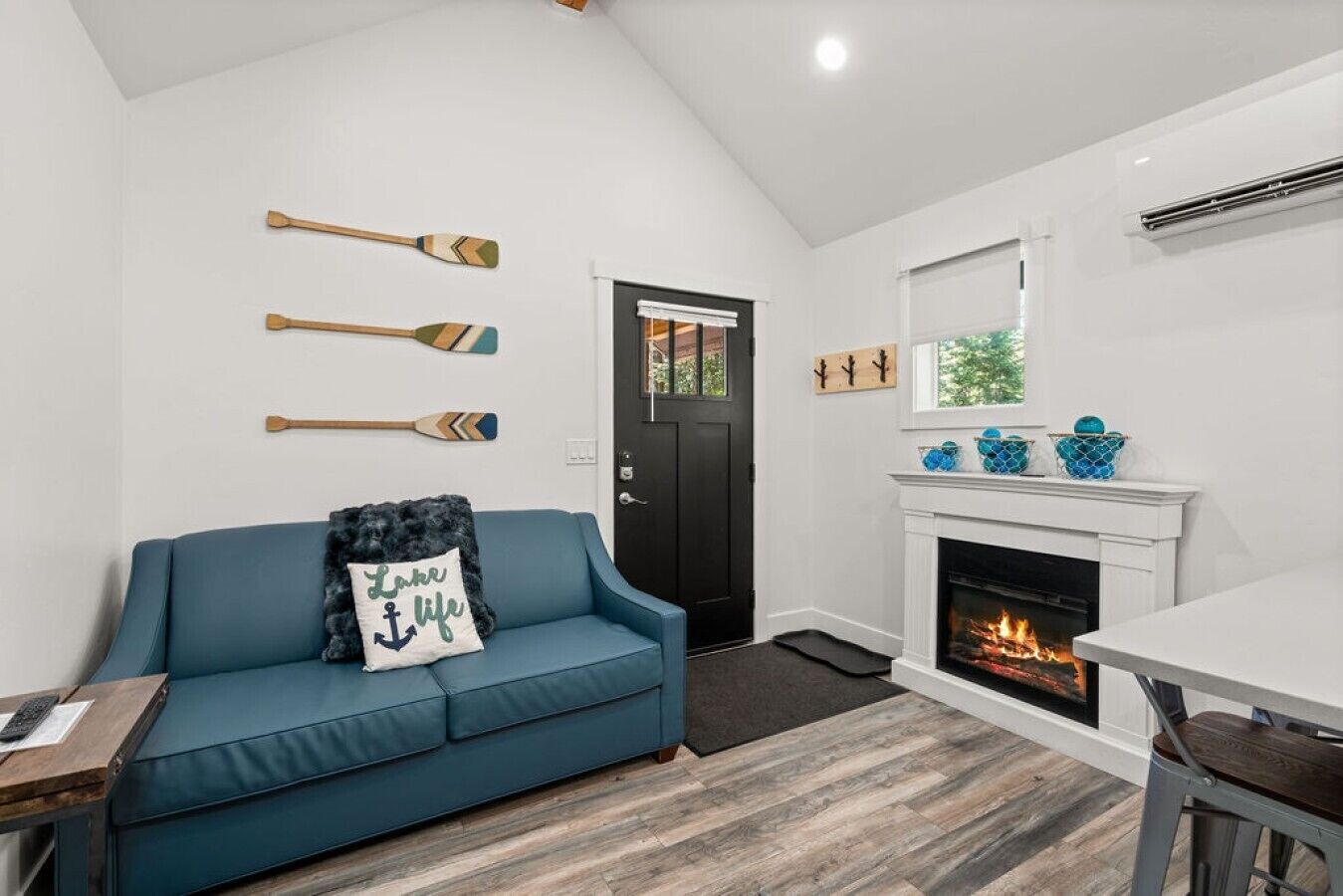 A living room with a blue sofa, a fireplace, and wall-mounted paddles.