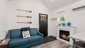 A living room with a blue sofa, a fireplace, and wall-mounted paddles.