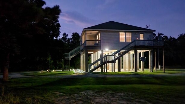 A two-story house with a balcony and a staircase leading to the second floor.