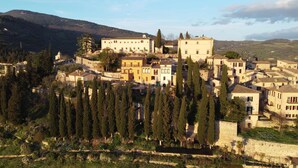 A hillside village with traditional architecture, terraced fields, and dense tree coverage. - Emerald apartment with valley view in the historic center (Spello)