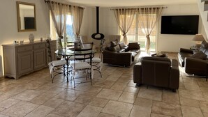 A spacious living area with a dining table, sofas, and a staircase. - Villa Avec Piscine Chauffée Nice Collines (Nice)
