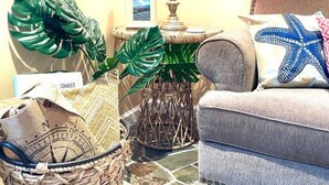 A cozy living room with a sofa, a lamp, and decorative plants. - Beach Gem! 2 bd with Hot Tub/3.7mi beach/.5mi outlets (Rehoboth Beach)