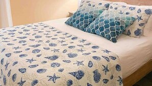 A bed with a blue and white patterned bedspread, a matching pillow, and a headboard. - Beach Gem! 2 bd with Hot Tub/3.7mi beach/.5mi outlets (Rehoboth Beach)