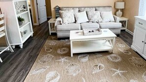 Una sala de estar con sofá, mesa de centro y objetos decorativos.