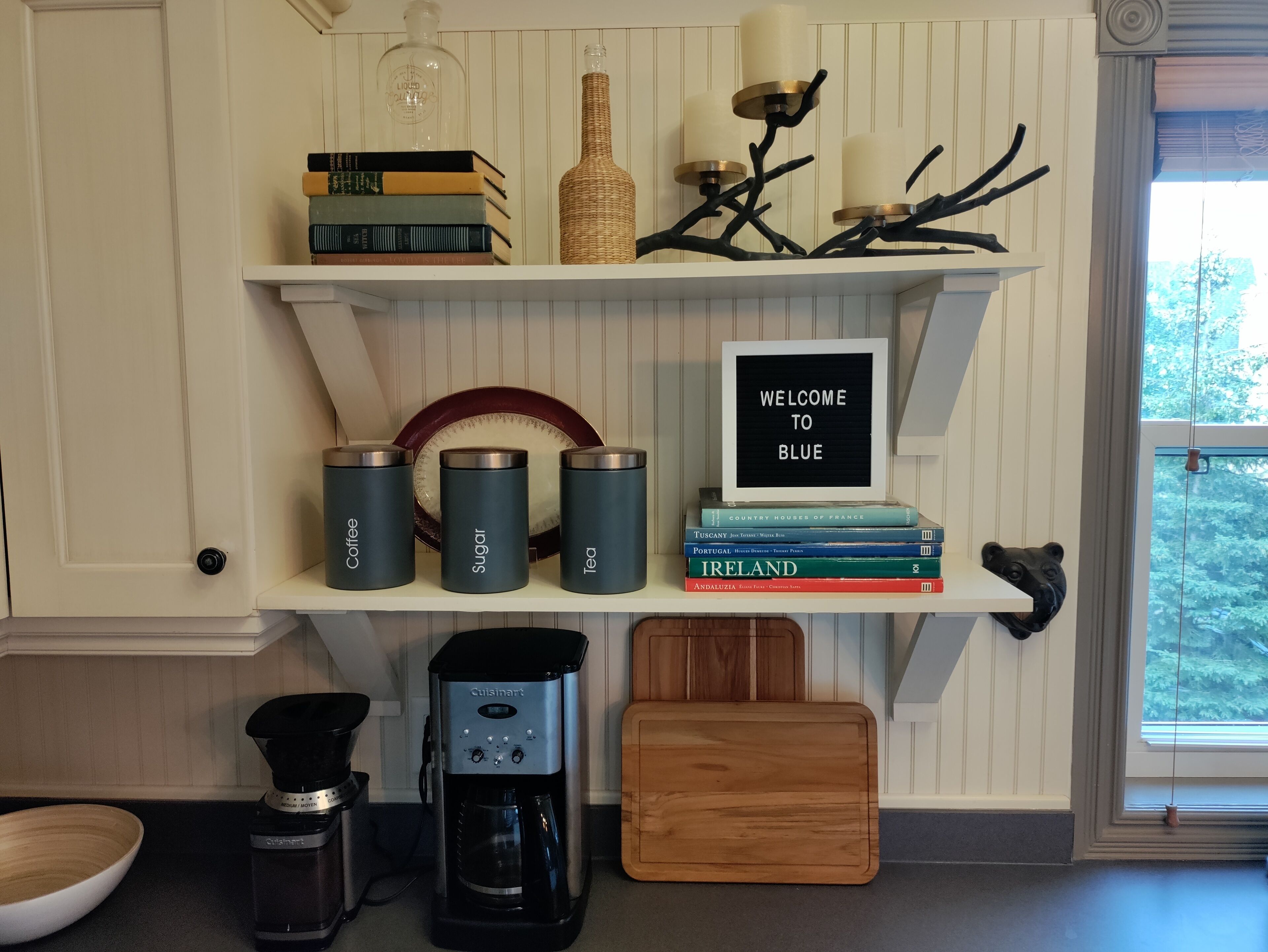 Une cuisine équipée d’une machine à café, d’une machine à expresso Cuisinart et d’un moulin à café, le tout posé sur le plan de travail.