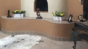 Un ambiente acogedor con chimenea, arte decorativo en la pared y una alfombra rústica.