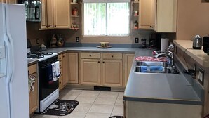 Una cocina con armarios de madera, una estufa, un lavabo y un ventanal.
