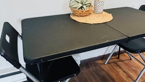 Une table de conférence avec quatre chaises, un set de table en fibres tressées, une plante en pot et un objet décoratif posé sur la table.