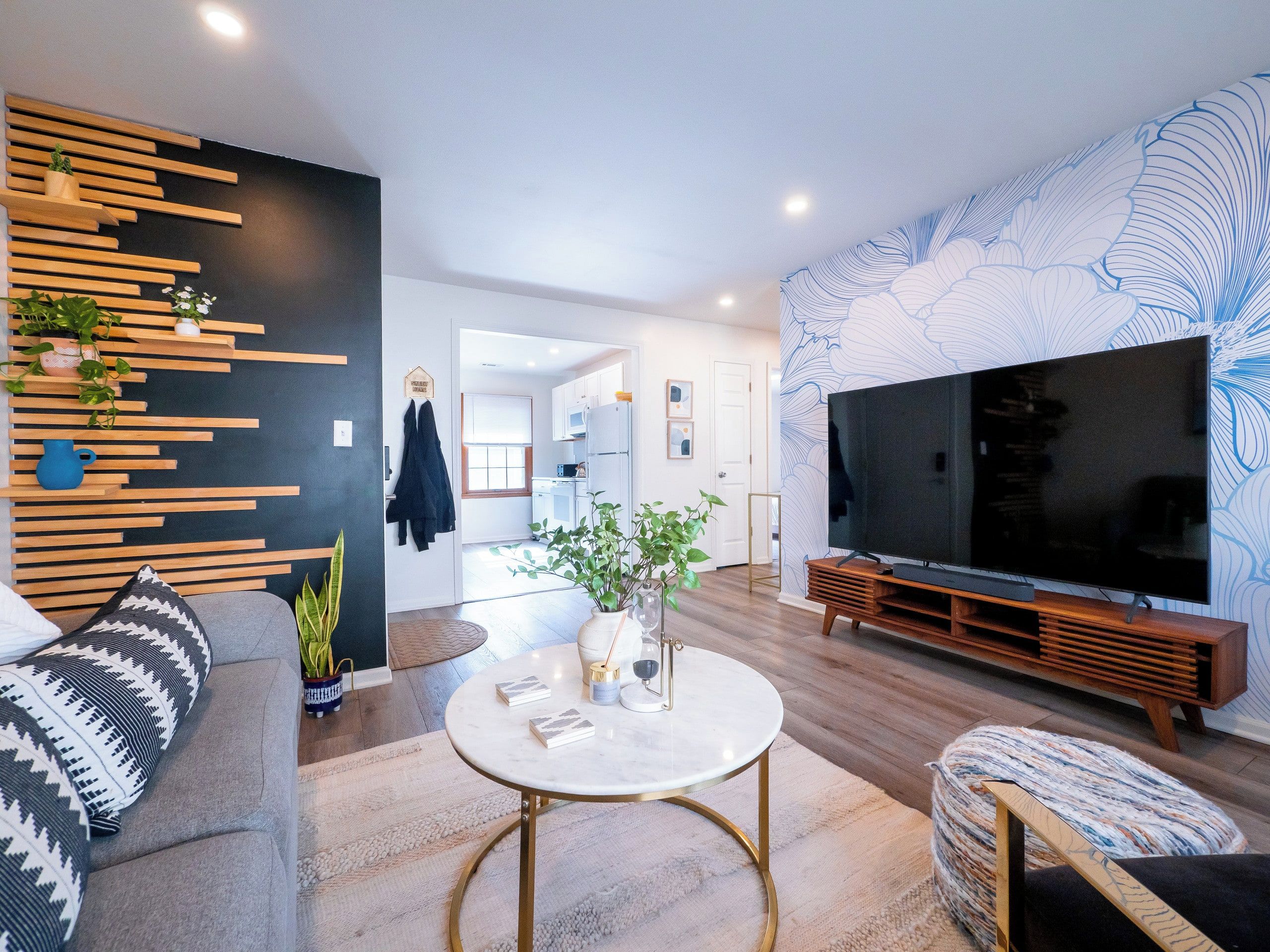 Un salon moderne avec un téléviseur à écran plat, une table basse ronde et un canapé.