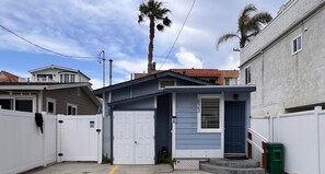 A residential property with a gated entrance, a garage, and a small porch. - Charming Beach Bungalow steps from the Ocean & Bay (San Diego)