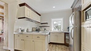 Una cocina con una isla central, electrodomésticos de acero inoxidable y un ventanal que proporciona luz natural.