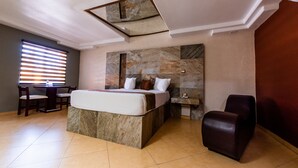 Ein Hotelzimmer mit einem großen Bett, einem Schreibtisch und einem Stuhl.