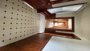 A room with a sloped ceiling, wooden flooring, a patterned wall, and a skylight. - Sundown Lodge in McMillan MI (McMillan)
