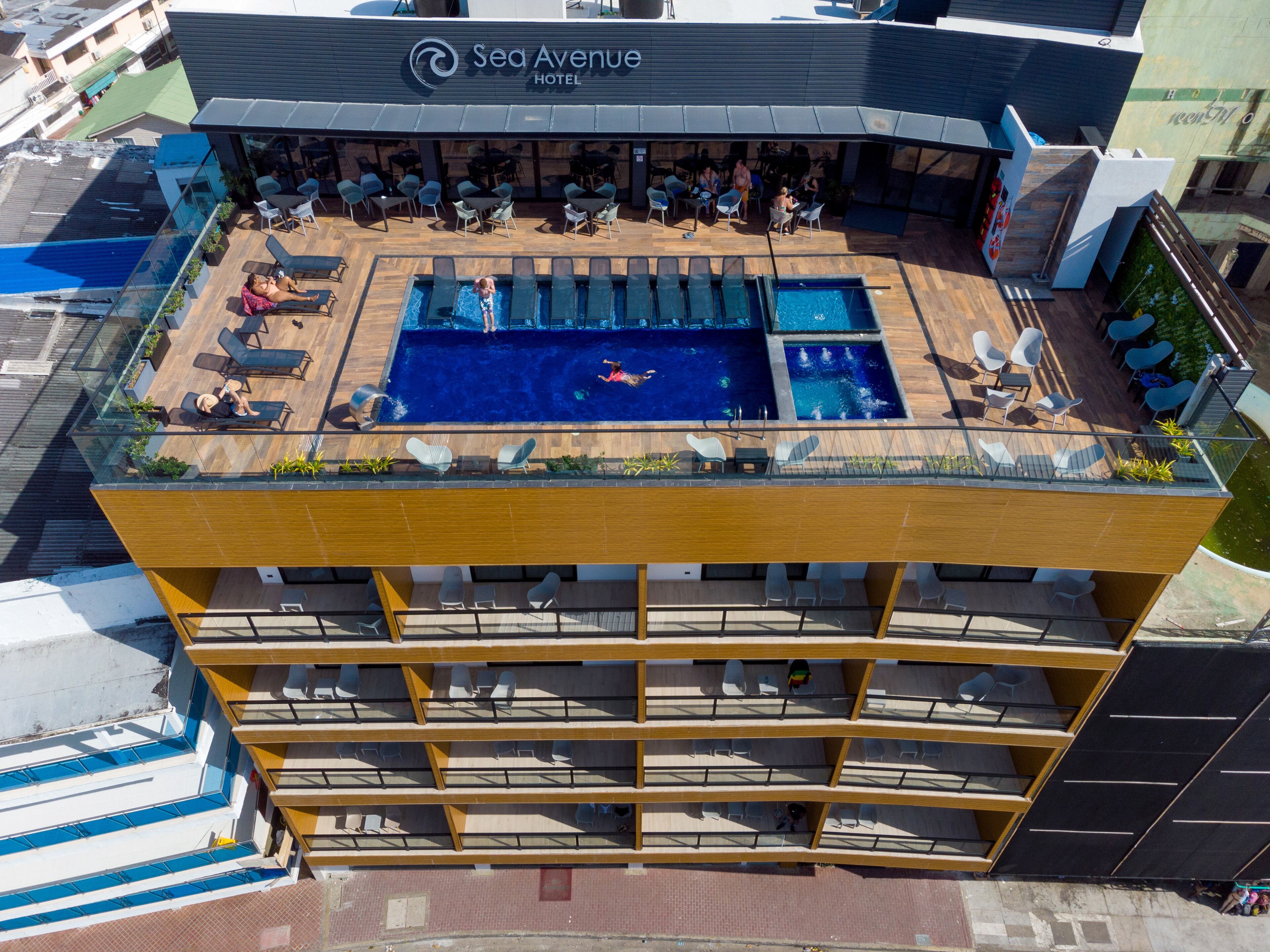 A rooftop pool area with multiple swimming pools and lounge chairs.
