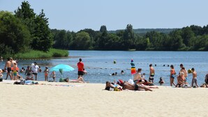 Une plage où des gens se prélassent au soleil et se baignent.