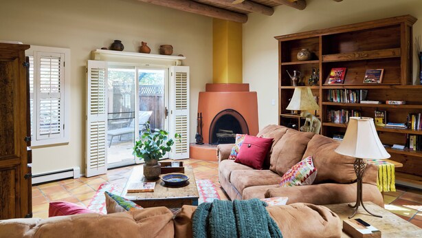 Ein gemütliches Wohnzimmer mit Kamin, einer Couch, einem Couchtisch und einem Bücherregal.
