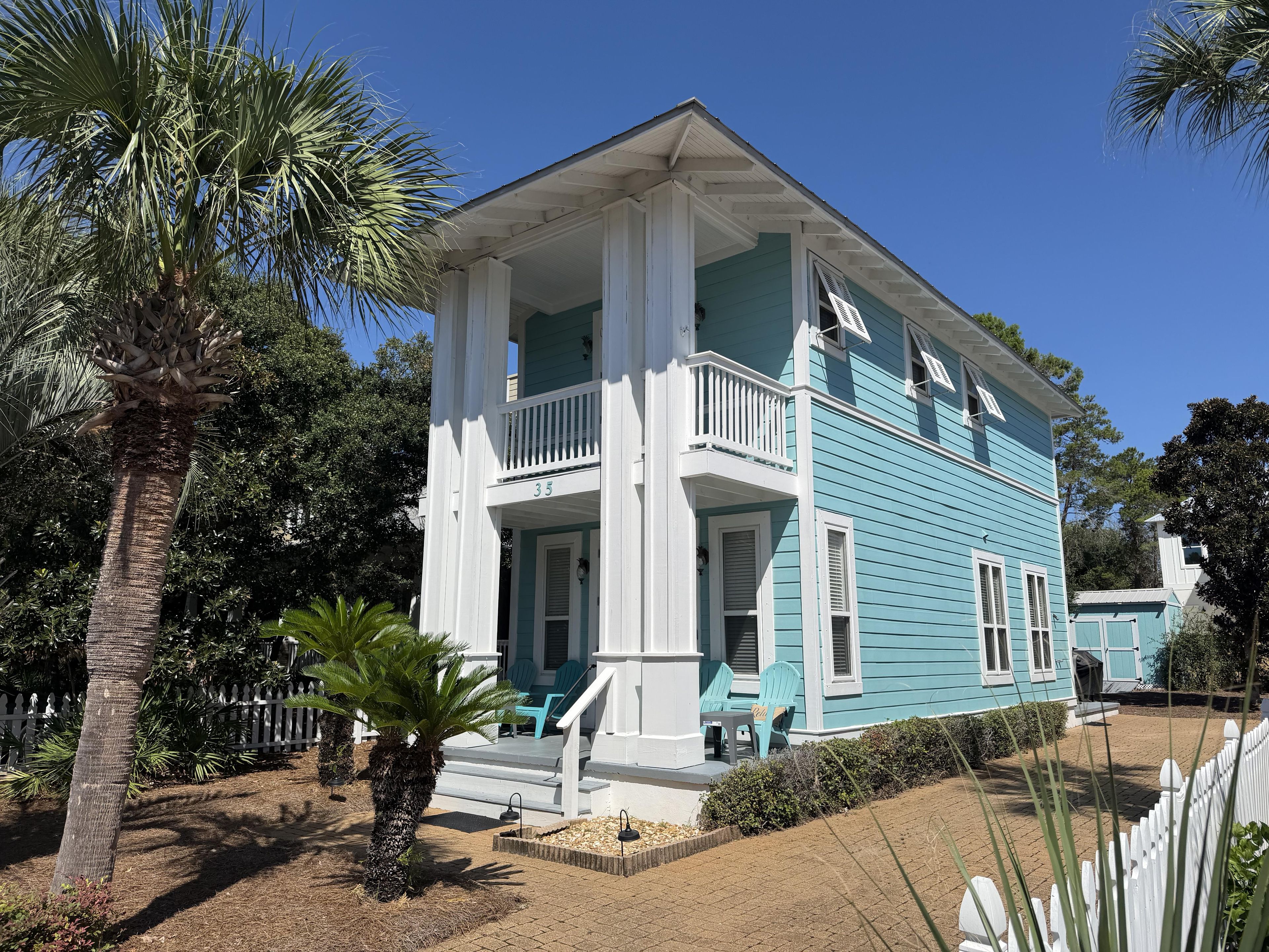 A two-story house with a porch, white columns, and a blue exterior.