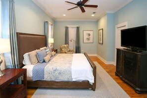 A bedroom with a bed, a ceiling fan, a dresser, a television, and a chair. - Life's a Beach | Dog Friendly, 2 Pools (Santa Rosa Beach)