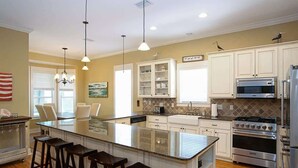 A modern kitchen with a large island, white cabinets, stainless steel appliances, and a bar area. - Life's a Beach | Dog Friendly, 2 Pools (Santa Rosa Beach)