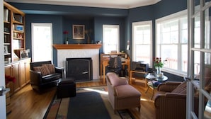 A living room with a fireplace, a bookshelf, and a dining area with a table and chairs.
