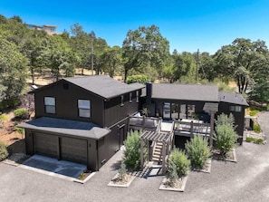 A modern two-story house with a garage, a covered patio, and a landscaped yard.