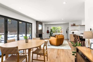 Una cocina moderna con comedor, ventanas amplias y chimenea.