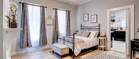 Un dormitorio con cama, mesita de noche y ventilador de techo.
