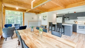 Una cucina moderna con isola centrale, elettrodomestici integrati e zona pranzo con tavolo e sedie in legno.