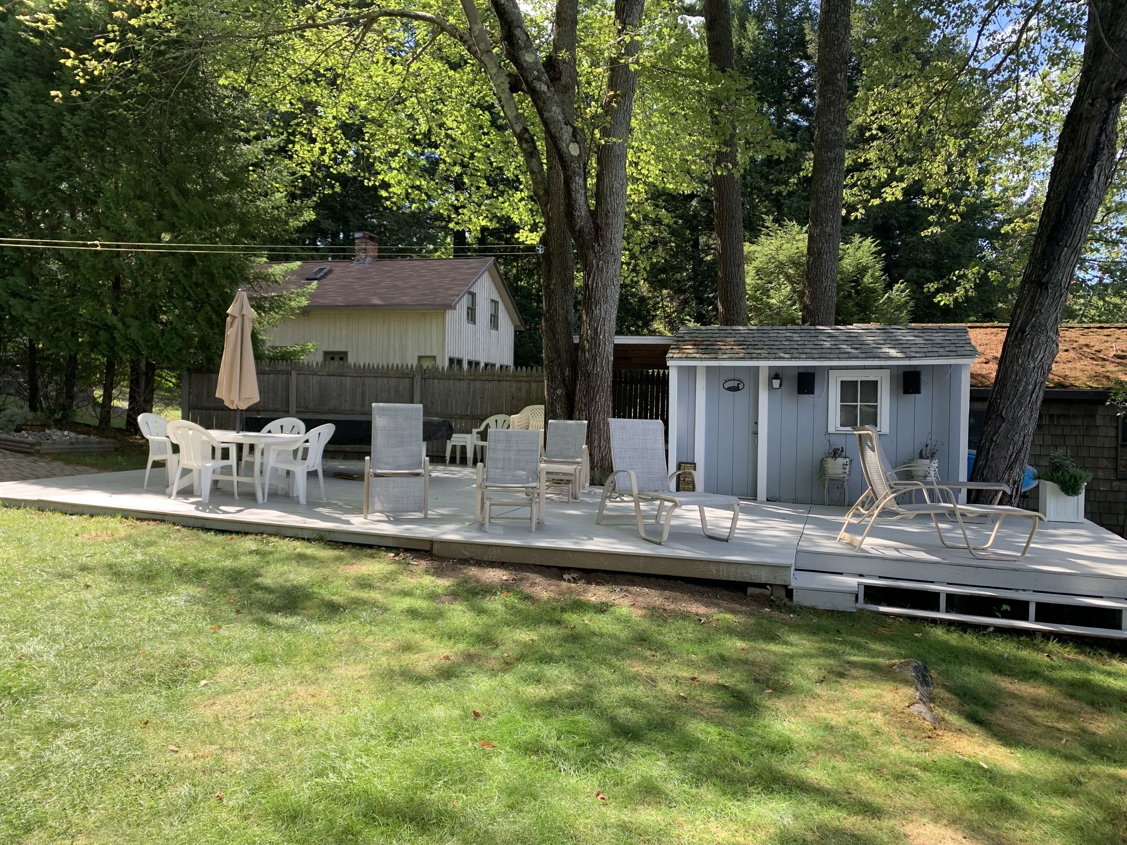 A backyard with a patio area, outdoor furniture, and a shed.