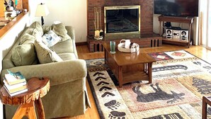 A living room with a fireplace, a television, a sofa, and a coffee table.