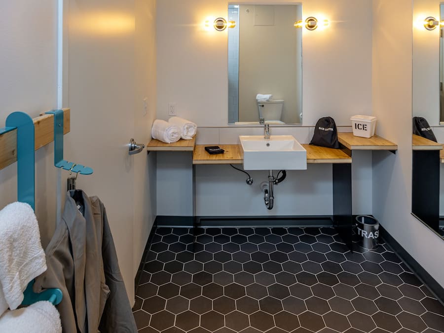 A modern bathroom with a sink, mirror, and hexagonal patterned floor.
