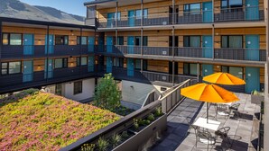 A multi-story hotel with balconies, outdoor seating, and a rooftop garden. - The Wren (Missoula)