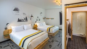 A hotel room with two wooden beds, a wall-mounted coat rack, and a shower area. - The Wren (Missoula)