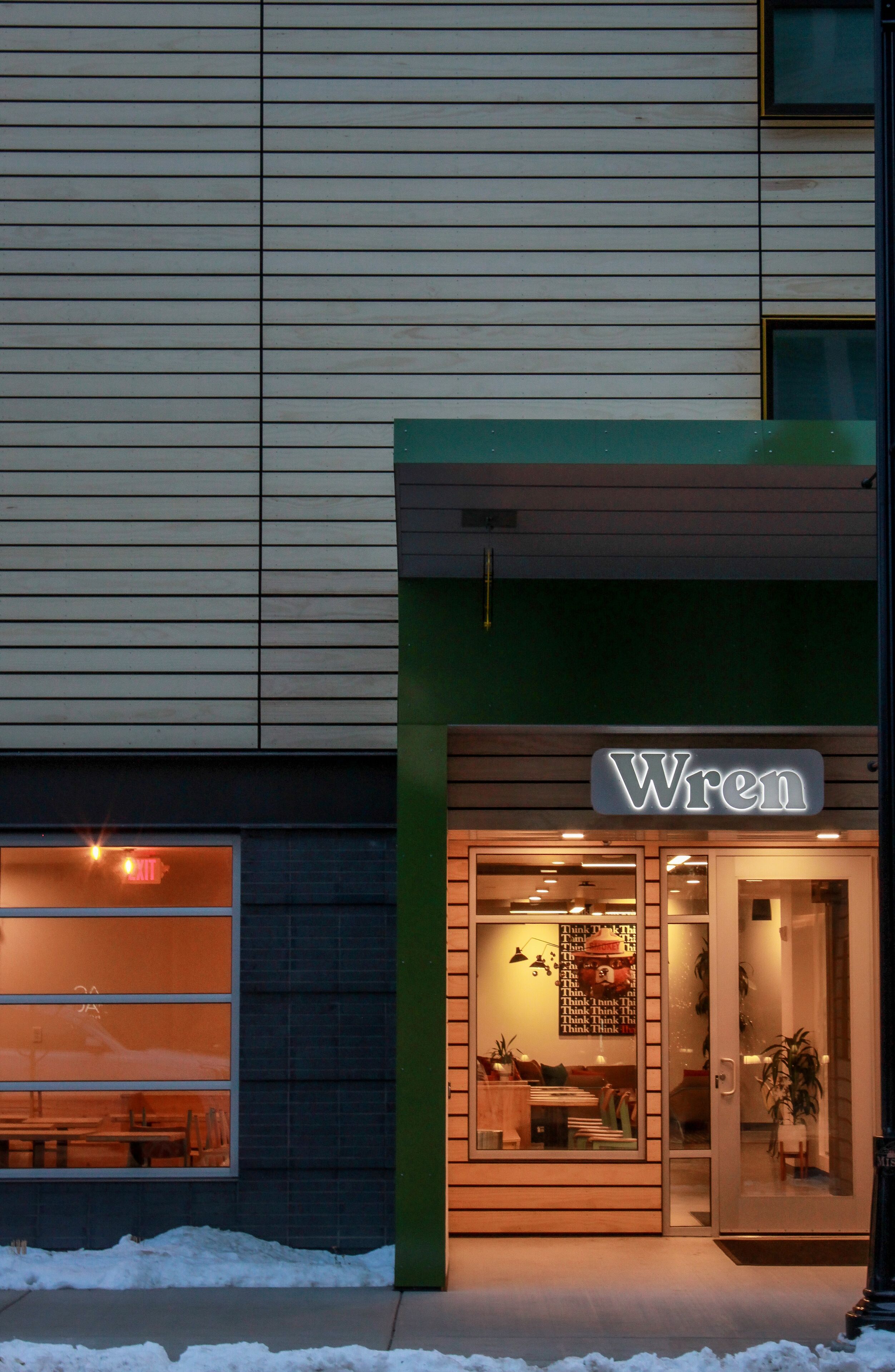 Um edifício com a placa 'Wren', uma janela visível e uma porta com painel de vidro.