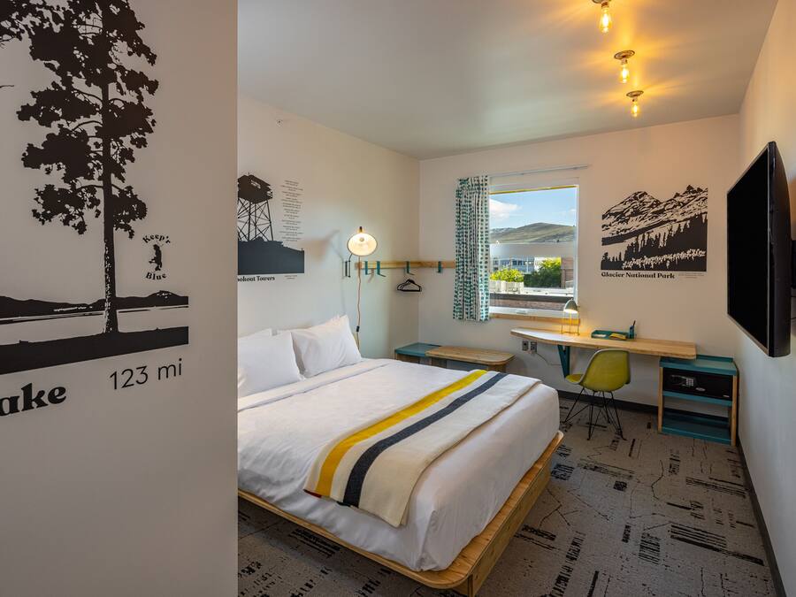 Une chambre d’hôtel équipée d’un lit, d’un bureau, d’une chaise et d’un téléviseur.