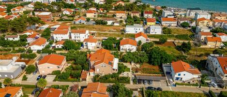 A residential area with houses, a swimming pool, and a view of the sea.