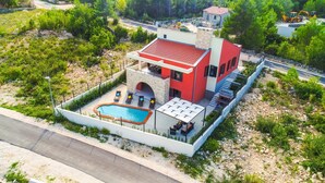 Eine moderne Villa mit Swimmingpool, Steingewölbe und einer Terrasse.