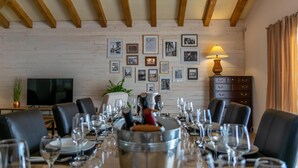 A dining area with a long table set for a meal, framed pictures on the wall, and a television in the background. - Villa Idassa Zadarvillas (Policnik)