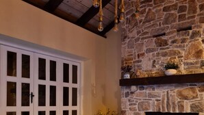 Ein Wellnessbereich mit Whirlpool, Steinwand, Holzboden und Kamin.