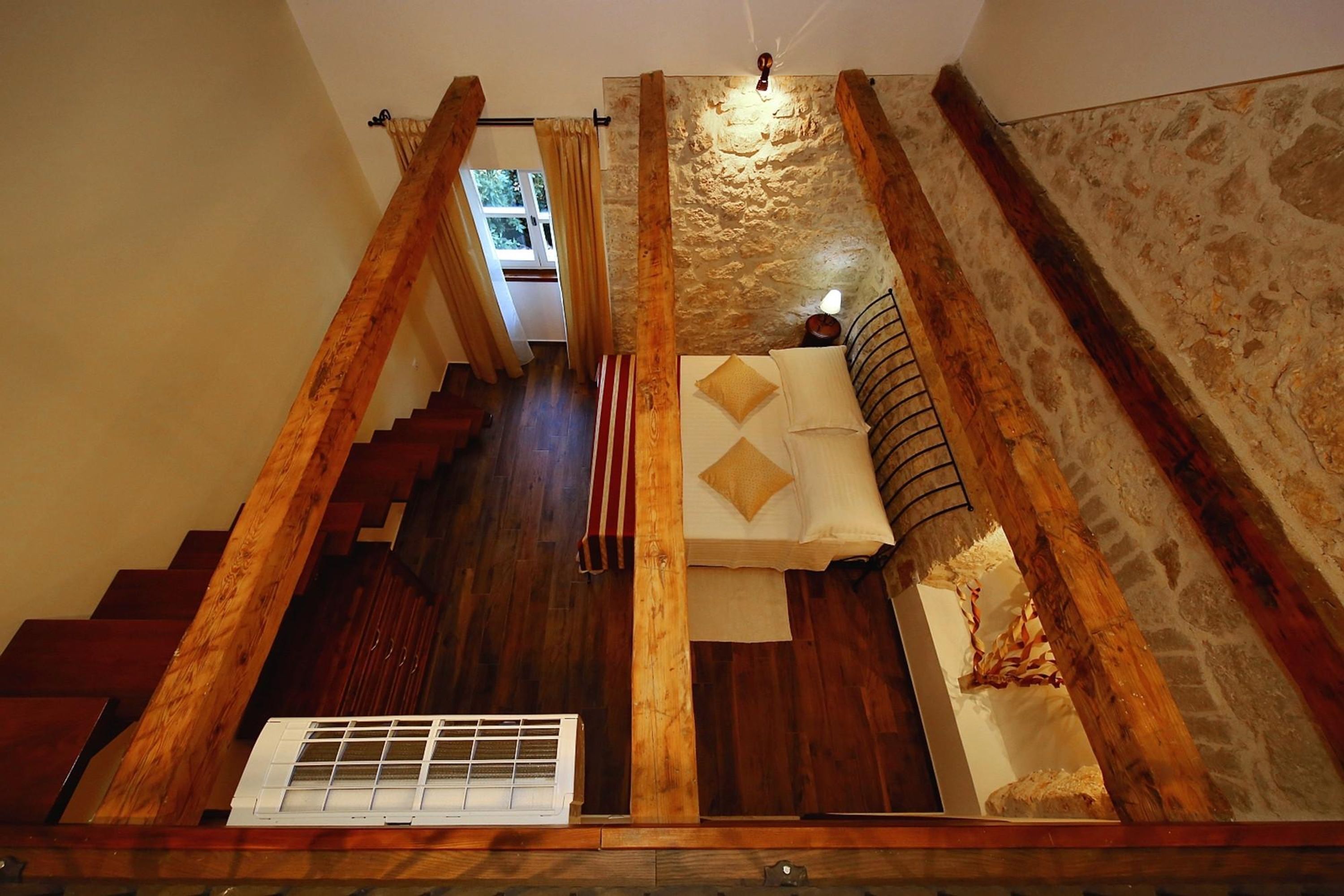 Uma escadaria de madeira com vista para um quarto.
