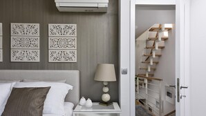 A bedroom with a bed, nightstand, lamp, decorative wall panels, and a staircase. - Villa Mirta Zadarvillas (Novigrad)