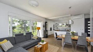 A modern living room with a sofa, coffee table, and dining area with chairs and a table. - Villa Mirta Zadarvillas (Novigrad)