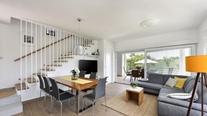 A modern living space with a staircase, dining area, sofa, and large windows. - Villa Mirta Zadarvillas (Novigrad)