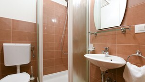 Ein Badezimmer mit Toilette, Dusche und Waschbecken.