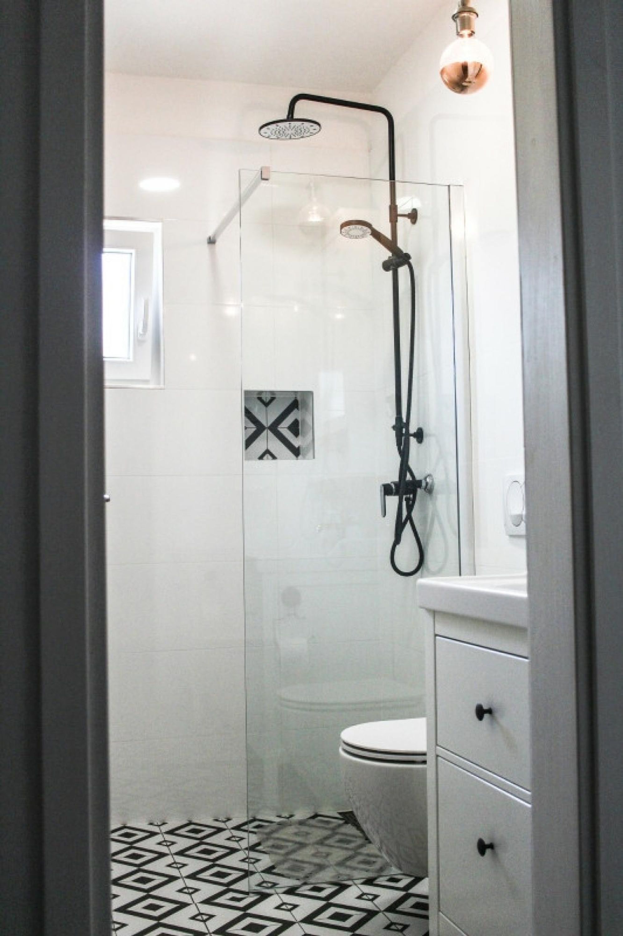 A modern bathroom with a glass-enclosed shower, a white toilet, and a tiled floor.