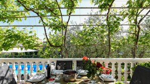 An outdoor dining area with a pool view, white balustrade, and greenery. - Villa Pine Zadarvillas (Kukljica)