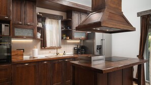 Une cuisine moderne avec des meubles en bois foncé, un îlot central et des appareils électroménagers intégrés.