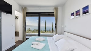 A modern hotel room with a large bed, a view of the sea, and a flat-screen TV mounted on the wall. - Villa Royal Promons Zadarvillas (Starigrad)