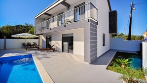 A modern two-story house with a balcony, a swimming pool, and a patio area with outdoor furniture. - Villa Lily Zadarvillas (Privlaka)